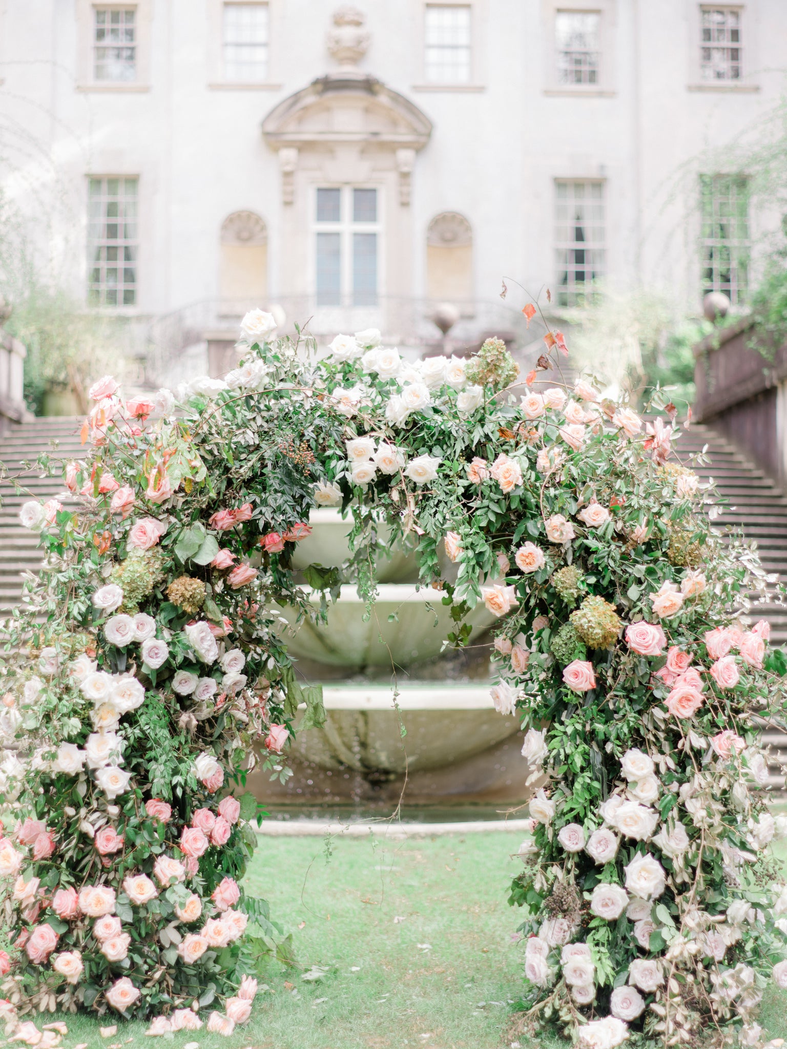 luxury pink pastel flower arch in front of the atlanta history museums swan house 