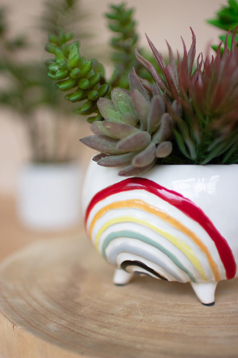 white ceramic planter with colorful rainbow on the front and faux succulent plants inside