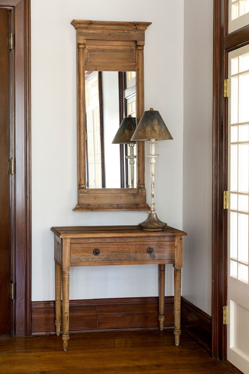distressed rustic table lamp on a wood side table with mirror on the wall