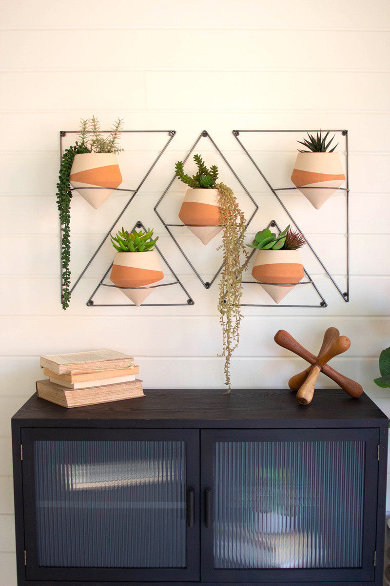 set of f ivory dipped clay pots with real artificial plants on a white wall  with books 