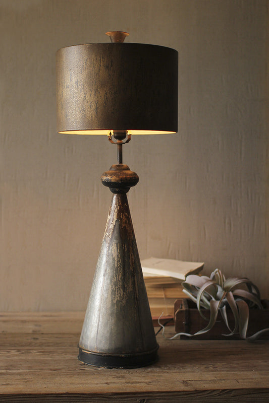 table lamp with metal base on a wood desk styled with books and air plant