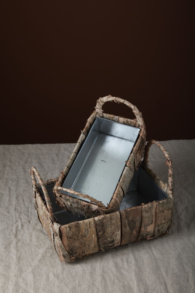 two birch wood baskets with handles on table cloth