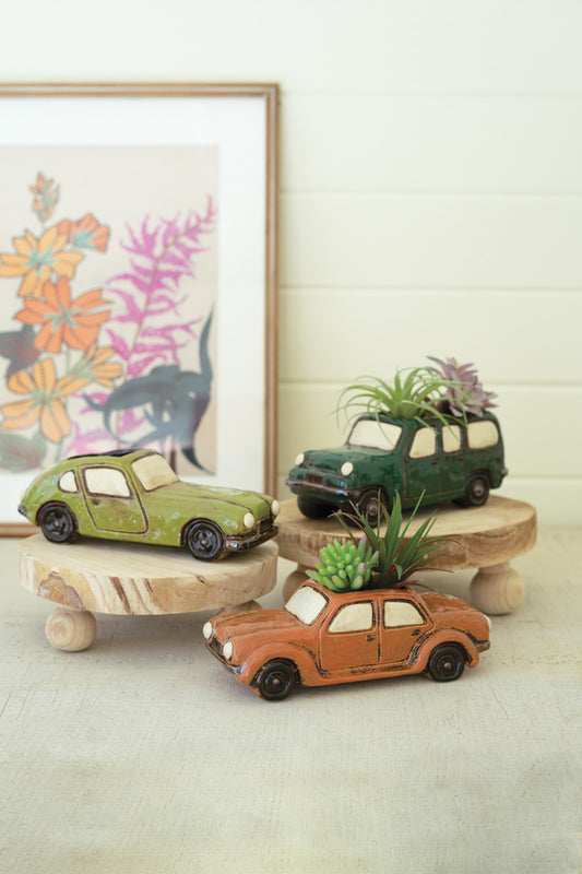 three small car planters with air plants and succulents with a picture frame and decor