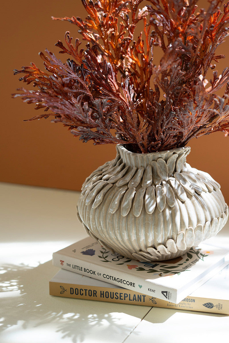 ceramic vase on books with flowers