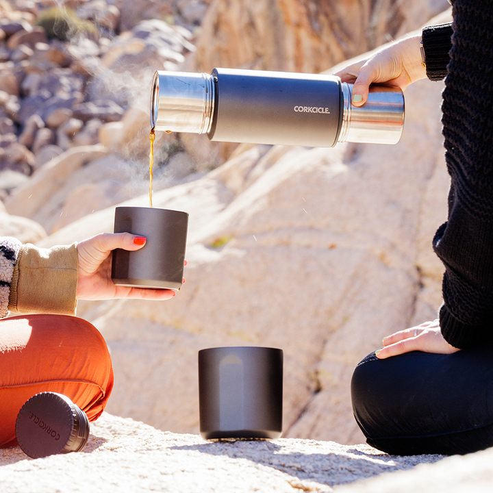 man and woman pouring a cup fo coffee from a grey Corkcicle thermos