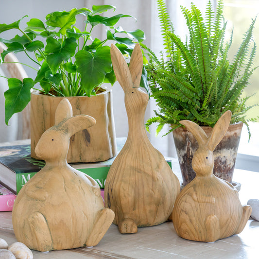 wood bunny rabbit decor on a table with real and faux plants