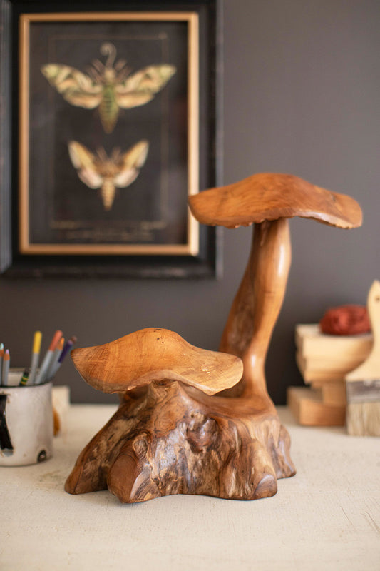 double teak wood mushroom decor styled on a desk with a pen holder and framed print on wall