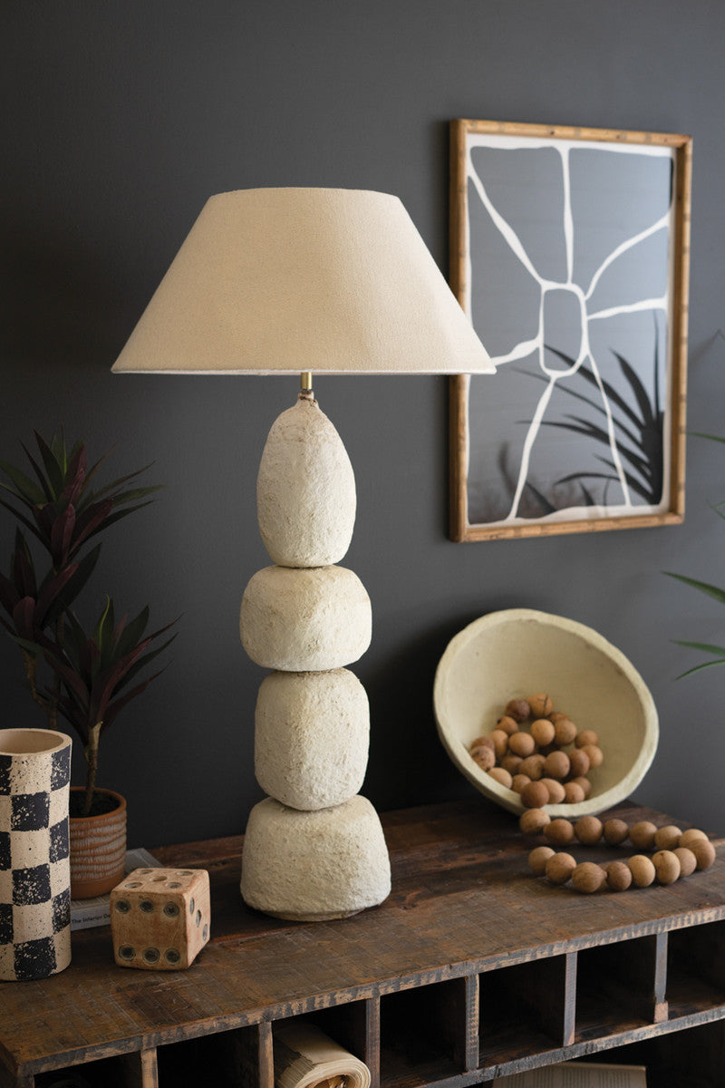 modern paper mâché lamp on decorated table with black wall
