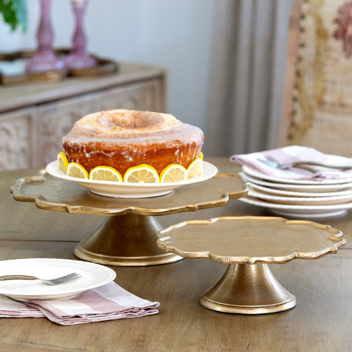 scalloped edge decorative aluminum gold cake plates with a cake on top of one 