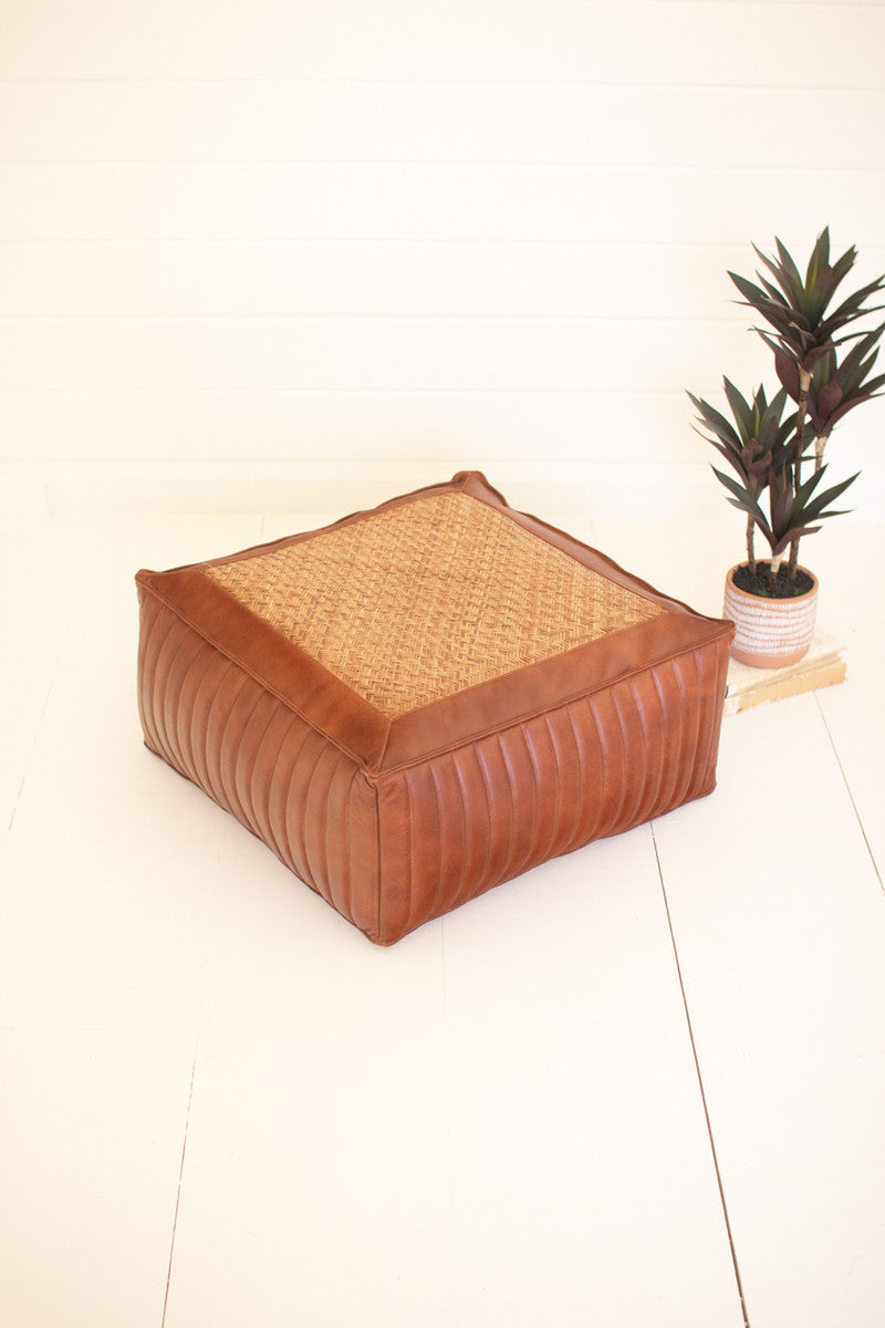 square brown leather pouf extra seating furniture with a plant beside it