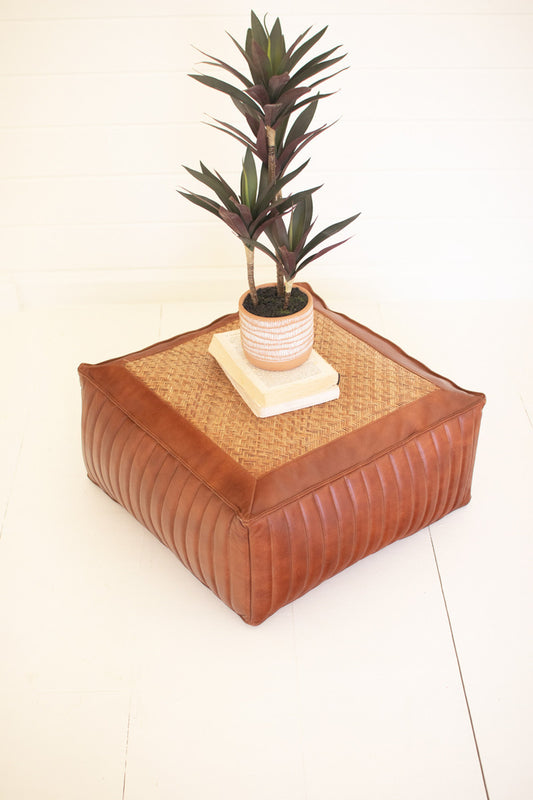 square leather ottoman with a faux real plant on top 