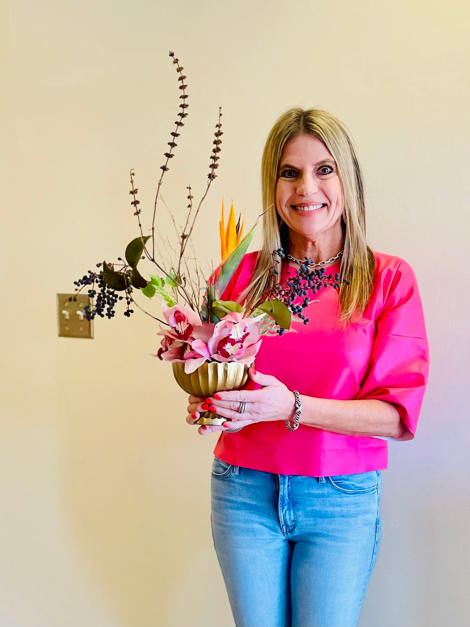 colorful Japanese ikebana style compote with flowers at workshop and woman in pink shirt