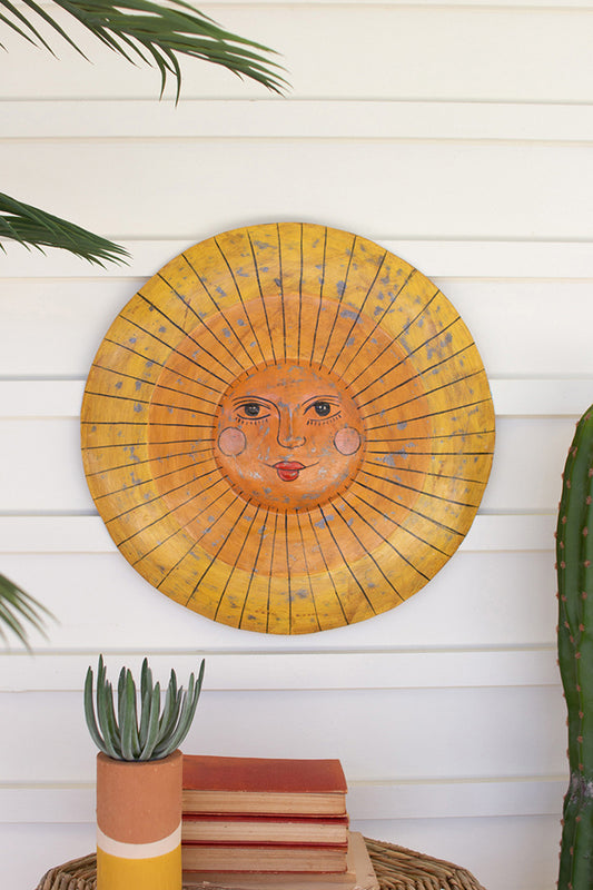 yellow metal sun wall art with succulent and book decor