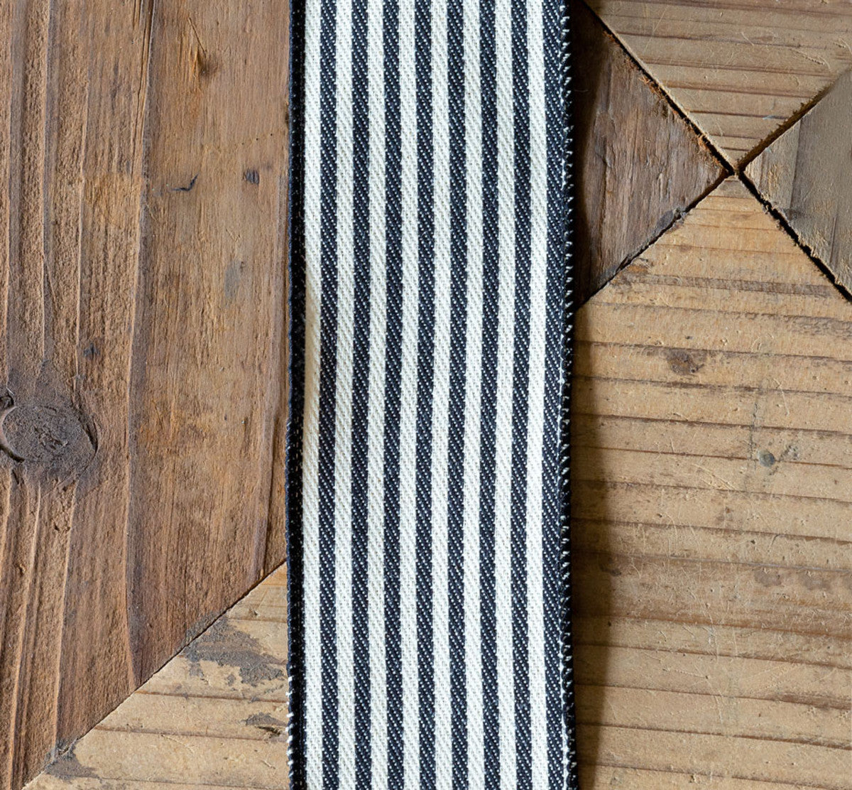 cream and black striped ribbon on a wood surface