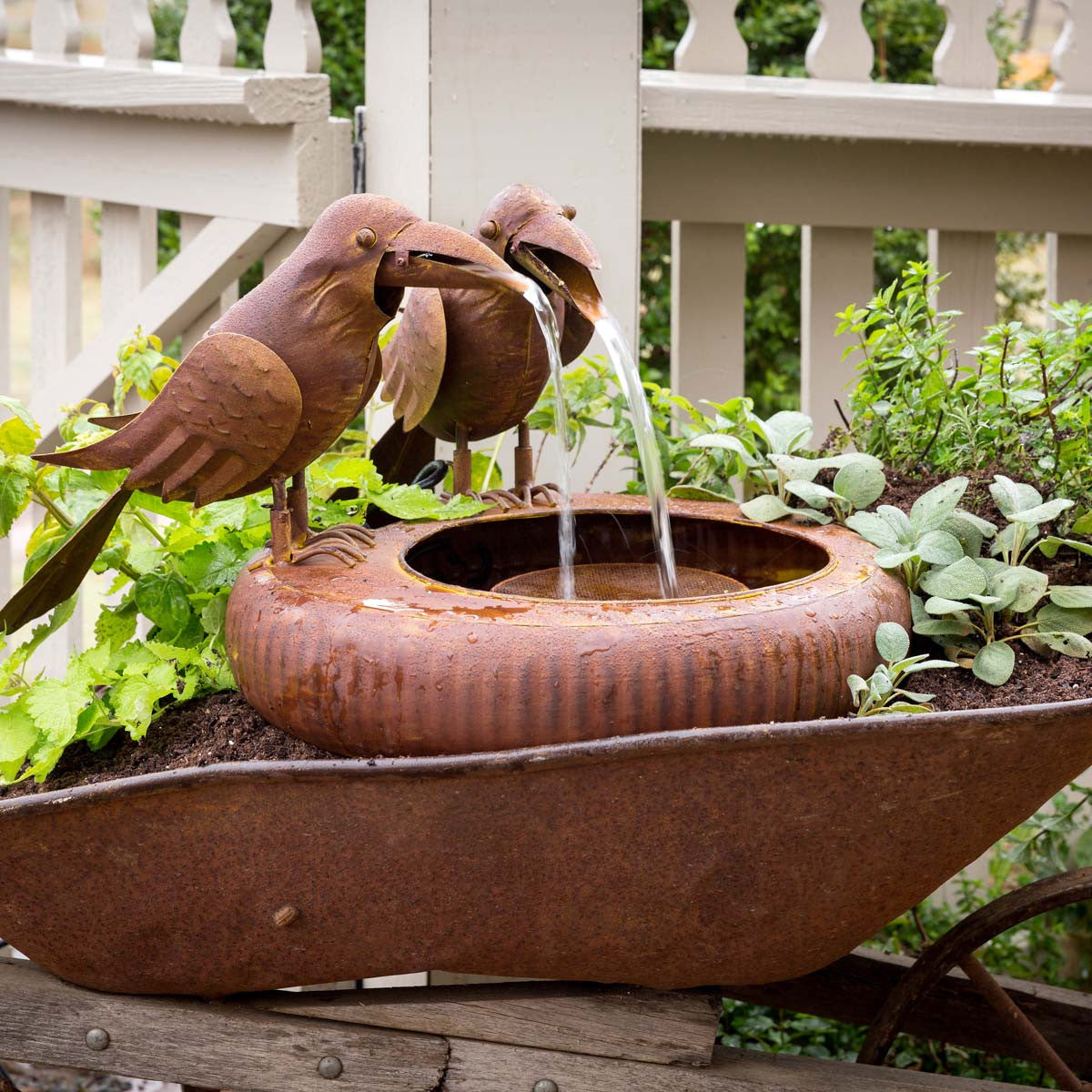 Vintage rustic crow bird water fountain in garden 