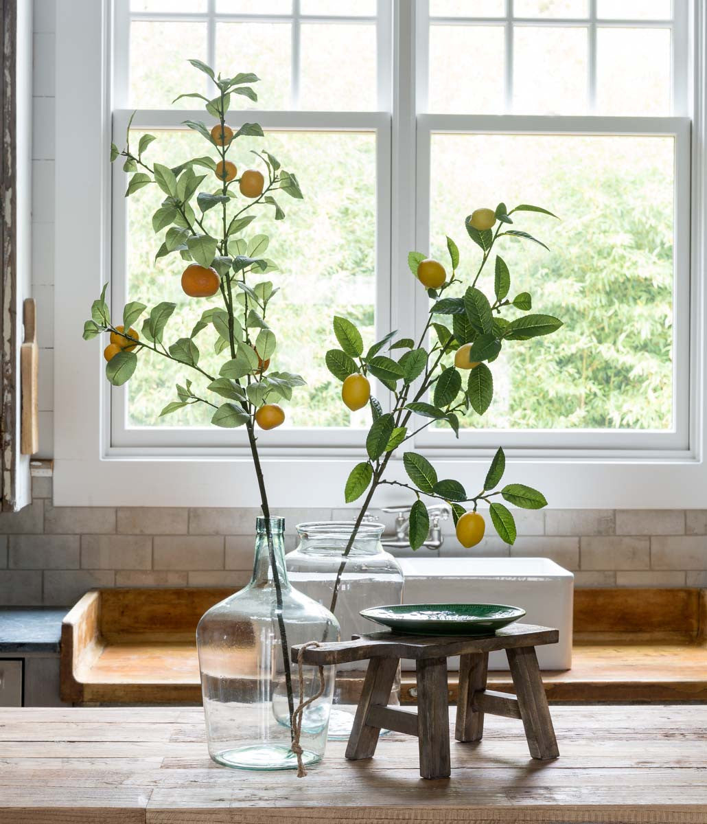 faux artificial tangerine branch in a vase in a kitchen