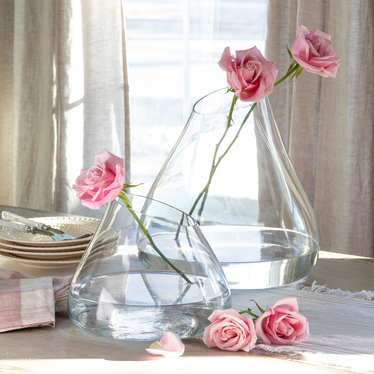 tear-drop-shaped-assymetrical-clear-glass-vases-with-pink-roses-near-a-window