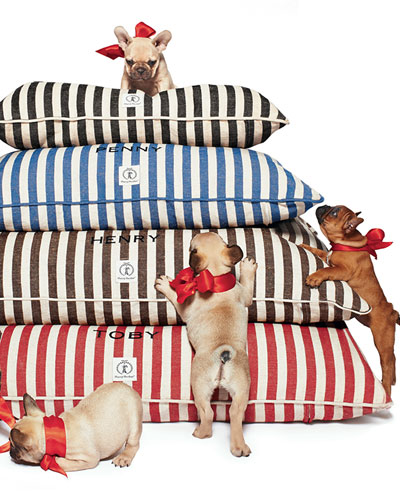 stack of vintage stripe dog beds with dogs with red bows on them