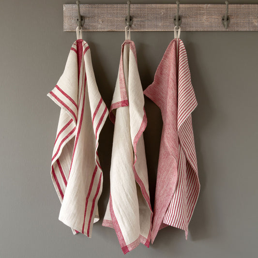 three red striped linen dish towels displayed on rustic rack