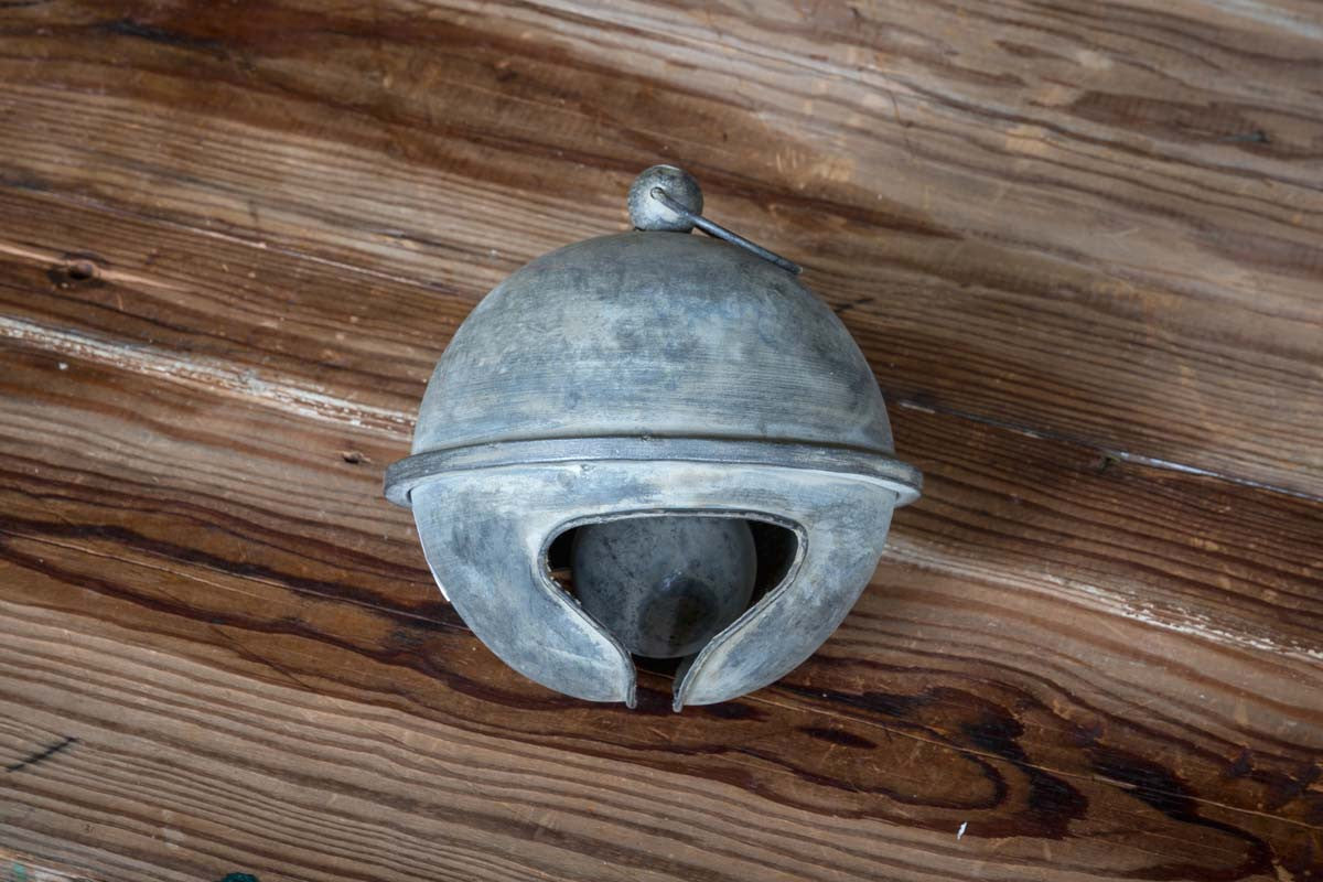 oversized-metal-christmas-holiday-bell-on-wood-table