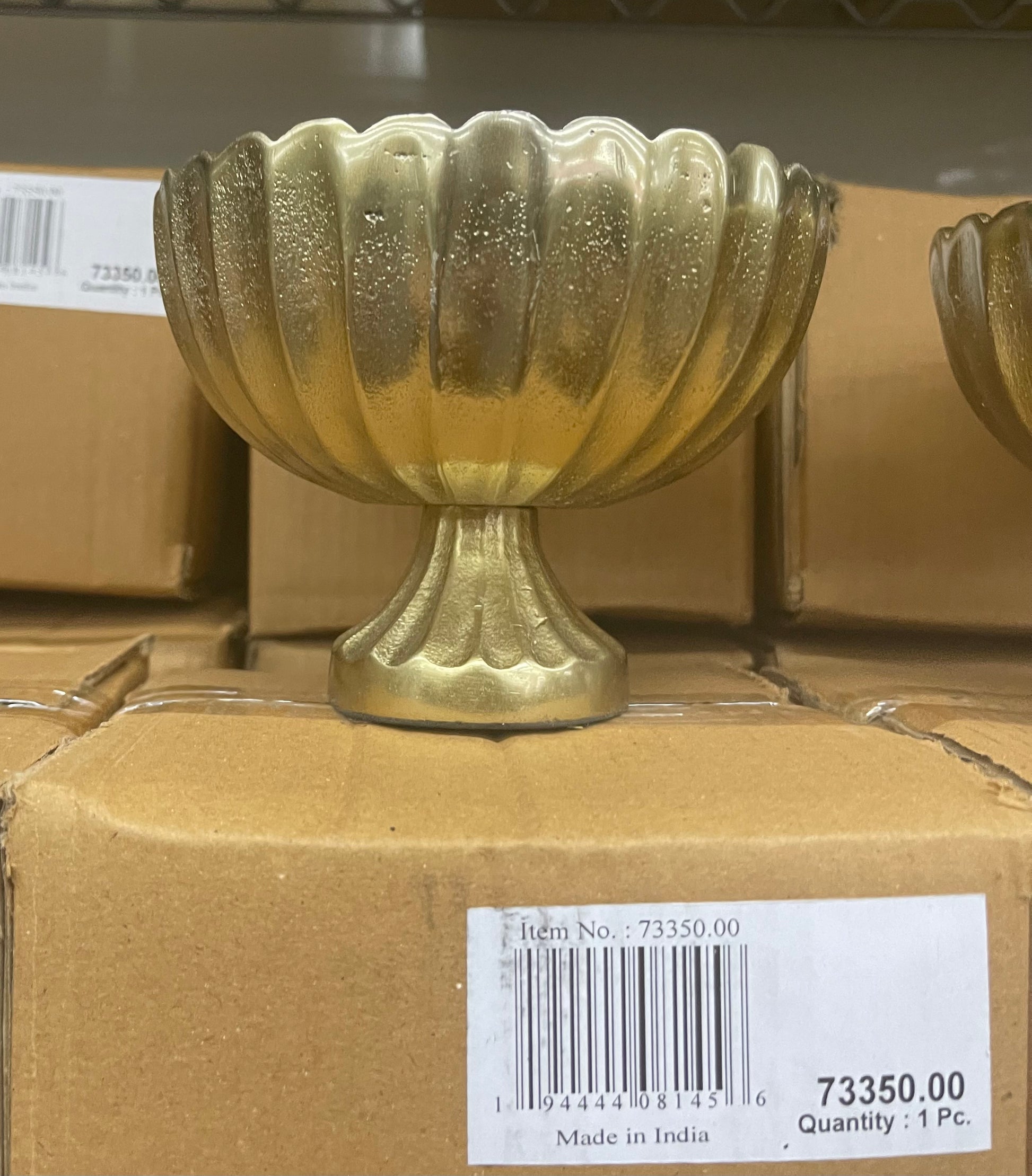one gold scallop edge compote vase on cardboard box