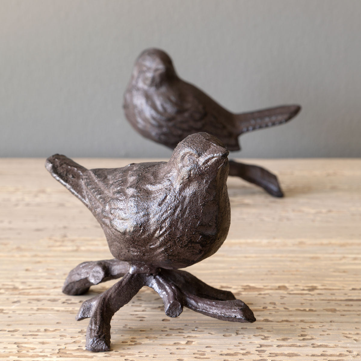 two iron perched bird decor on wood table